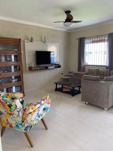 a living room with a couch and a tv at Vila Sunset Saquarema RJ in Saquarema