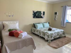 a bedroom with two beds with towels on them at Vila Sunset Saquarema RJ in Saquarema +42 photos