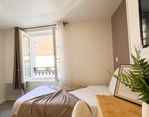 a bedroom with a bed and a window at Studio B4 - Centre-Ville Meaux - Proche Disneyland in Meaux