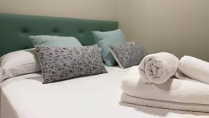 Una cama con toallas y almohadas. en Carude 76, en Monforte de Lemos