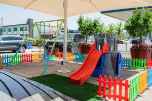 a playground with a slide and a swing set at The One Boutique Hotel in Muçaj