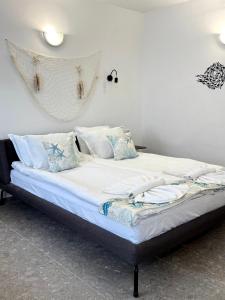 a bed with white sheets and pillows in a room at Hotel Mistral in Nesebar