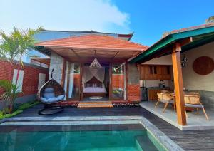a house with a swimming pool in front of a house at Maharatu Suite Villa in Ubud