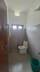 a small bathroom with a toilet and a window at Hillnest Homestay in Ambalavayal