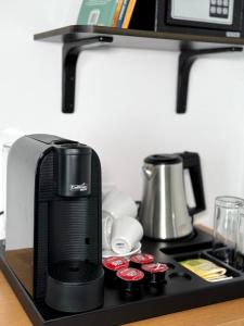 a black coffee maker on a black shelf at Hotel Mistral in Nesebar