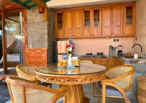 a kitchen with a table with chairs and a counter at Maharatu Suite Villa in Ubud