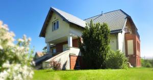 a house on top of a grassy hill at Mysi Dwór Pokoje Gościnne Lublewo in Lublewo