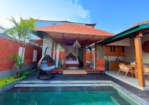 a house with a swing and a swimming pool at Maharatu Suite Villa in Ubud