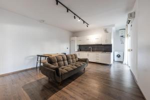 a living room with a couch and a kitchen at Saranda Beach Living - 1BR Apartment in Sarandë