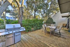 a backyard with a stove and a table with chairs at Pool Access and Pet Friendly Condo in Hilton Head in Hilton Head Island
