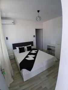 a bedroom with a bed with a black and white blanket at Vila Atlas Constanta in Constanţa