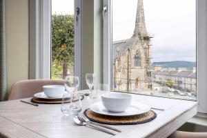 a table with plates and glasses and a view of a church at Munro Guest House in Stirling
