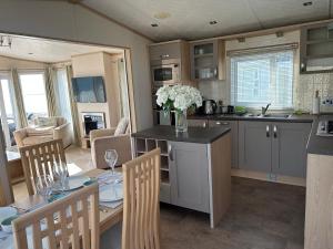 a kitchen with a table with a vase of flowers at Unobstructed Sea Views , Rockley Park , Poole in Lytchett Minster