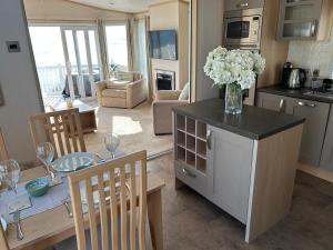 a kitchen and living room with a vase of flowers on a counter at Unobstructed Sea Views , Rockley Park , Poole in Lytchett Minster +20 photos