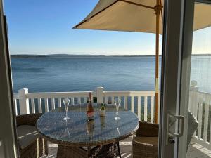 a table with a bottle of wine and glasses on a balcony at Unobstructed Sea Views , Rockley Park , Poole in Lytchett Minster
