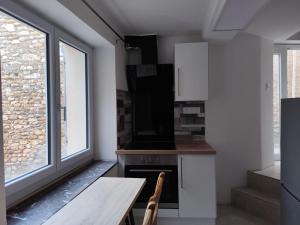 a kitchen with a table and a stove and windows at Hosted by Françoise in Valensole