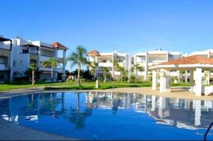 a large swimming pool in front of some buildings at Apparemment de luxe Asilah Marina Golf in Asilah