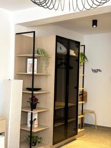 a book shelf with a glass door in a room at Hotel Mistral in Nesebar