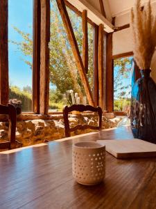 une table en bois avec un vase au-dessus dans l'établissement Les Volets Bleus, à Cormont