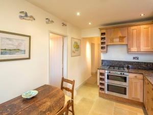 a kitchen with a wooden table and a dining room at Rhiw 2 Bryn Tirion in Rhiw