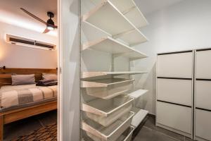 a closet with white shelves and a bed at "Sun down" by Corralejobeach Apartments in Corralejo