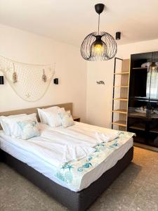 a bedroom with a large bed with a chandelier at Hotel Mistral in Nesebar