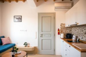 a small kitchen with a blue couch and a table at Assyr A - Santorini Cozy Cycladic Retreat in Santorini