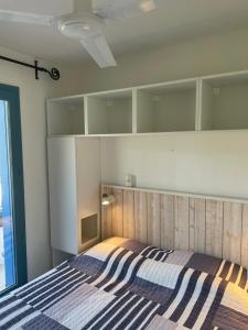 a bedroom with a bed with a striped blanket at MAZET - Domaine de la Pinède PRAMOUSQUIER - Le Lavandou in Le Lavandou