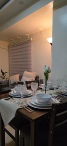 a dining room table with plates and wine glasses at 2BR Bi-Level BGC Skyline 150mbps WiFi in Sampong