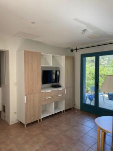 a living room with a tv and a entertainment center at MAZET - Domaine de la Pinède PRAMOUSQUIER - Le Lavandou in Le Lavandou
