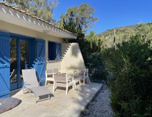 a patio with white chairs and a house at MAZET - Domaine de la Pinède PRAMOUSQUIER - Le Lavandou in Le Lavandou +9 photos