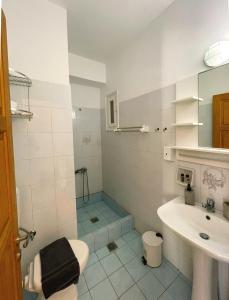 a bathroom with a sink and a shower and a toilet at New Poseidon Apartments & Studios in Skala Eresou