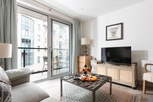 a living room with a couch and a tv at Vespasian's Abode by Grandeur Property in Poole