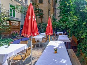 rząd stołów z czerwonymi parasolami w obiekcie Westend City Hostel w Wiedniu
