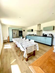a kitchen with a table and chairs in a room at Maison rénovée en centre-ville, à 5 min des plages in Beaussais sur Mer