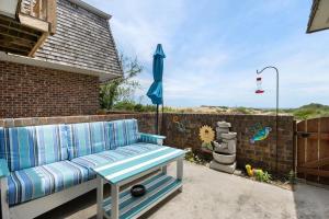 un banco azul en un patio con sombrilla en The Mermaid Lounge, en Nags Head