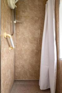 a shower with a white shower curtain in a bathroom at Swingletree Cottage in Bridlington