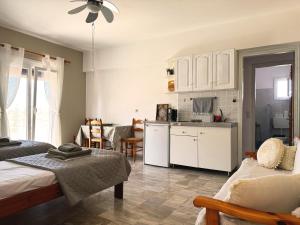 a living room with two beds and a kitchen at New Poseidon Apartments & Studios in Skala Eresou
