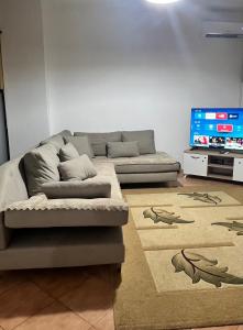 uma sala de estar com um sofá e uma TV de tela plana em Inn house em Tirane