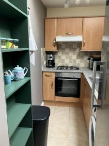 a kitchen with wooden cabinets and a stove top oven at Charmante petite maison de campagne in Le Tréhou