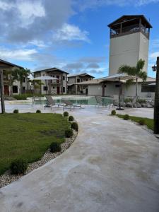 a patio with benches and a building with a pool at Chalé Betel Santo Amaro in Santo Amaro