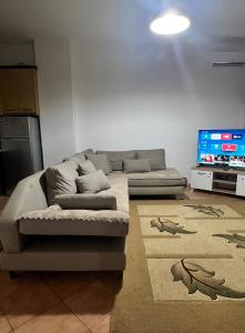 uma sala de estar com um sofá e uma TV de tela plana em Inn house em Tirane