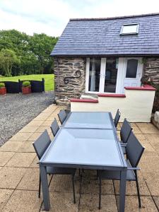 a table and chairs in front of a house at Charmante petite maison de campagne in Le Tréhou