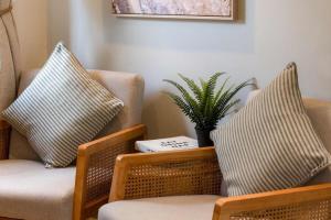 un soggiorno con due sedie e una pianta di Cottage Central Location Parking Fireplace Garden a Bourton on the Water