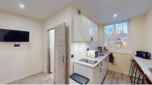 a kitchen with white cabinets and a sink and a window at Jupiter Paris in Champigny-sur-Marne
