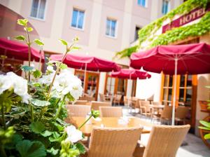 un restaurante con mesas y sillas con sombrillas púrpuras en Austria Classic Hotel Wien, en Viena