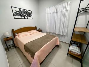 a small bedroom with a bed and a ladder at Descanse em meio a natureza com muito charme in Monte Alegre do Sul