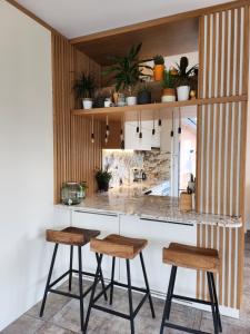 a kitchen with two stools and a counter with plants at Ma-Bebe Play House with Private Sauna --- Lake, Parks and SPA Pools in 5 min in Pancharevo