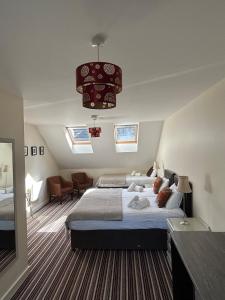 a bedroom with two beds and a chandelier at 11 The Avenue in Killarney