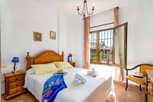 een slaapkamer met een bed, een bureau en een raam bij Villa Tres Olivos by Villa Plus in Frigiliana +36 foto's